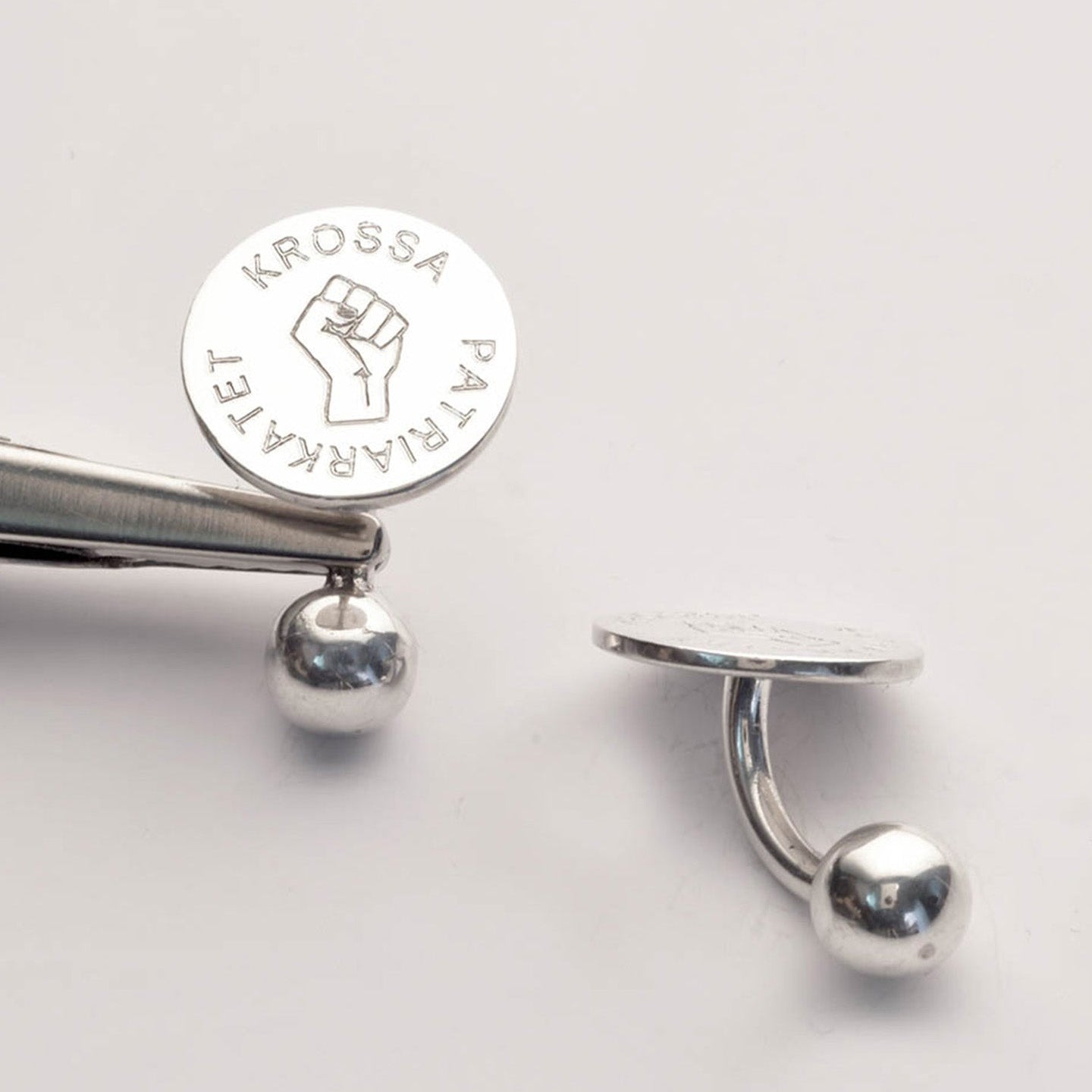 Accessoarer med kvinnotecken i silver från Feministsmeden.