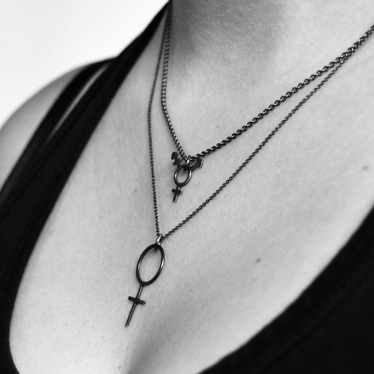 Smycken med transsymboler i silver och guld från Feministsmeden, skapade för stolthet, styrka och gemenskap.